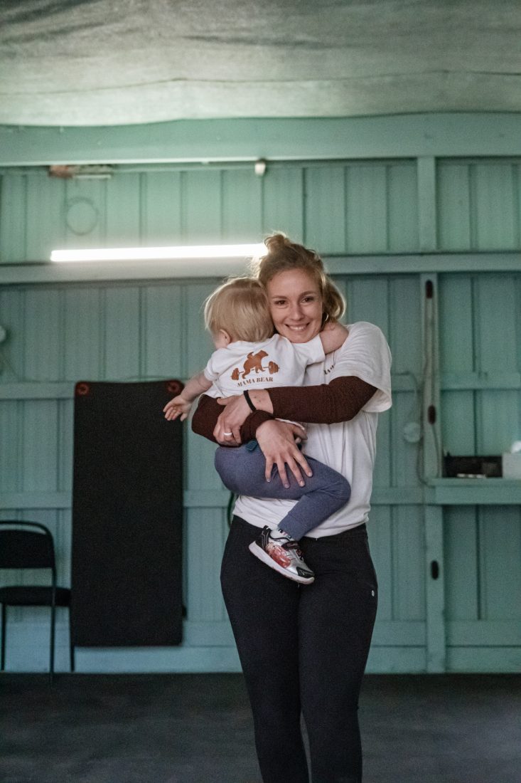 Jess Parcher holding her toddler in the Mama Bear Fitness gym