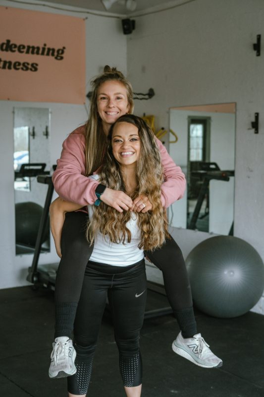 Jess and a client laughing together in the gym